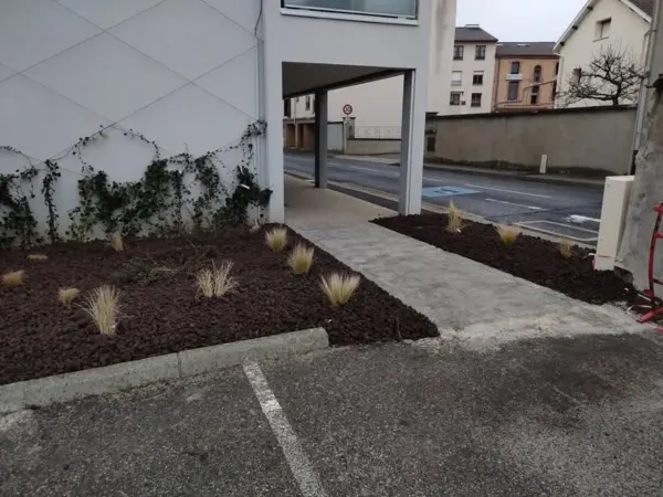 Massif minéral en pouzzolane, graminées et mur végétalisé